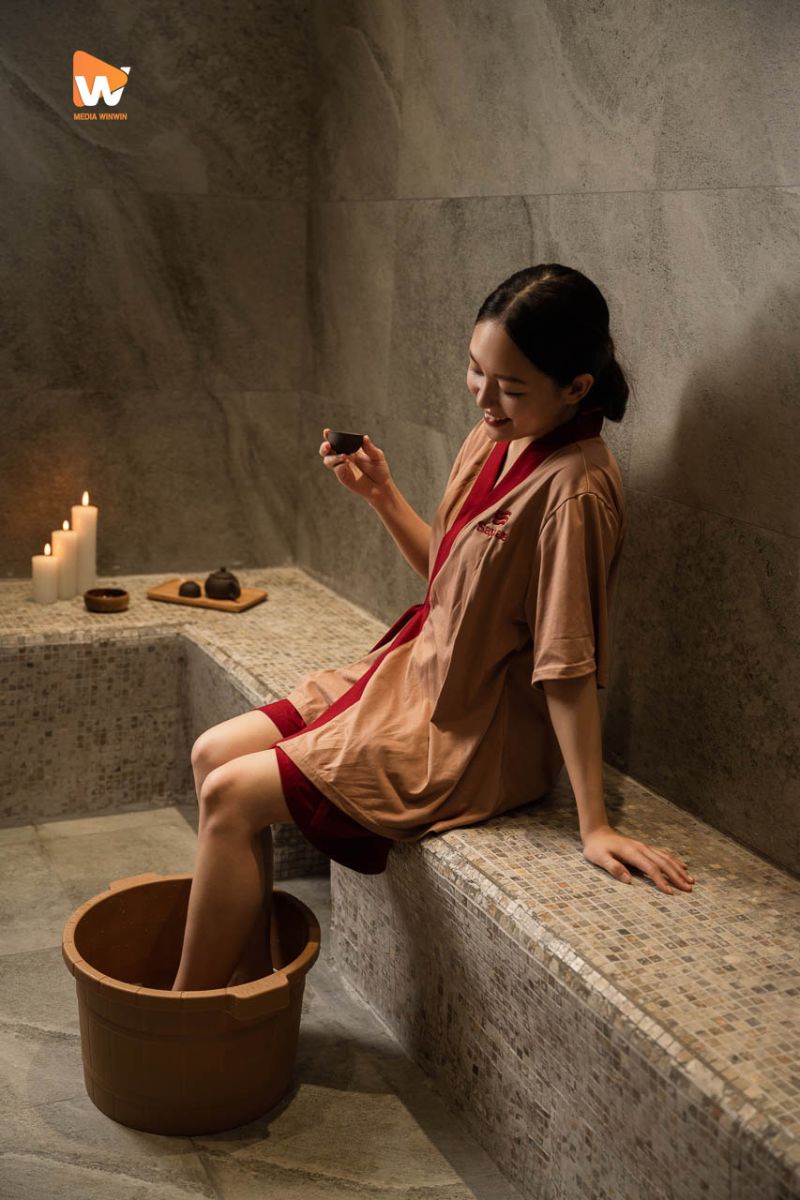 Khách nữ ngâm chân bằng thau gỗ bên bậc đá tại Savillas Spa