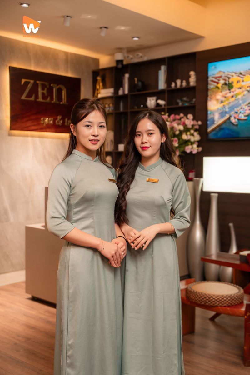 Hai nhân viên Zen Spa & Tea trong áo dài xanh tại quầy lễ tân