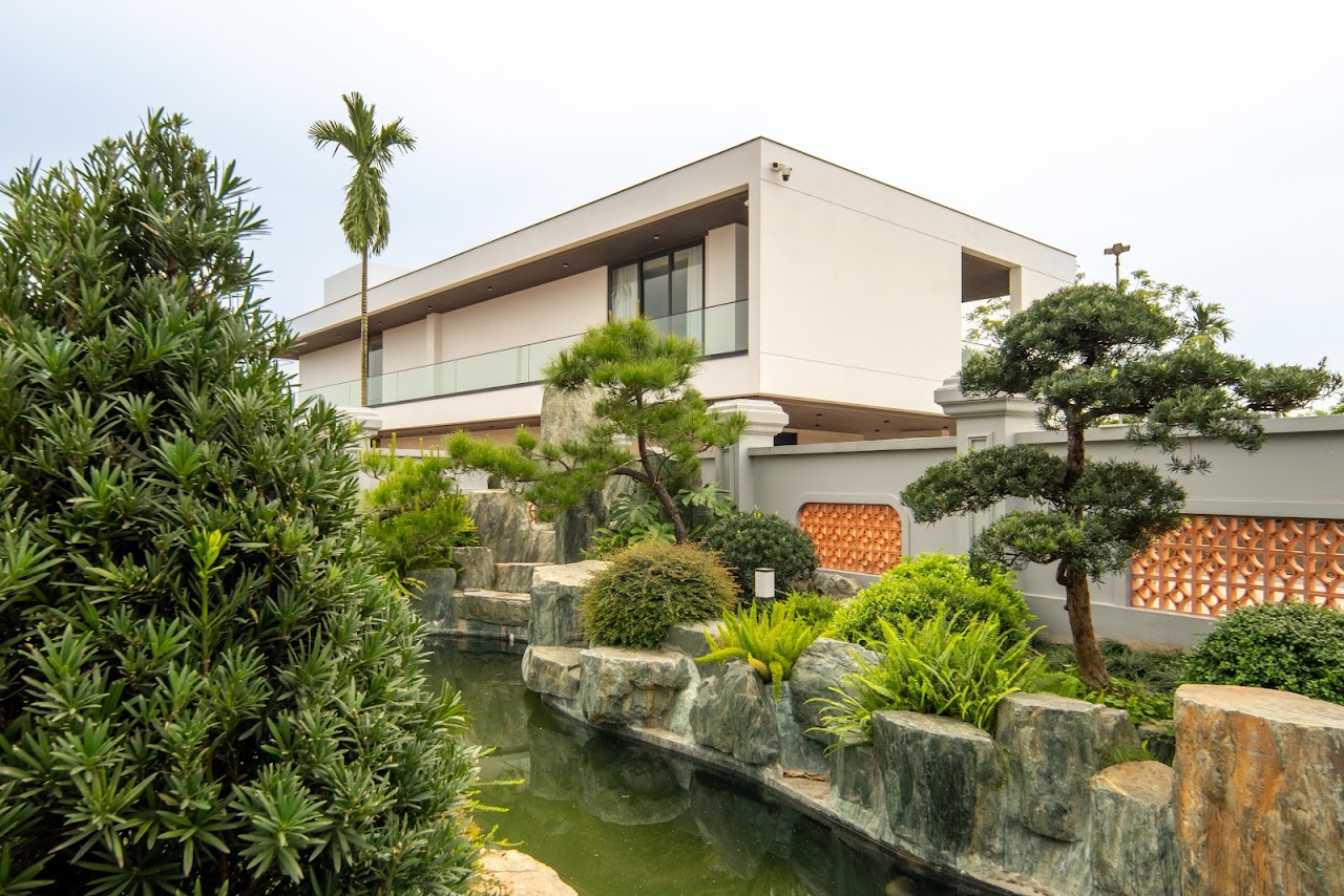 chụp ảnh kiến trúc villa Bắc Giang - khuôn viên có villa hiện đại, hồ nước kè đá và mái ngói đỏ nhà thờ họ