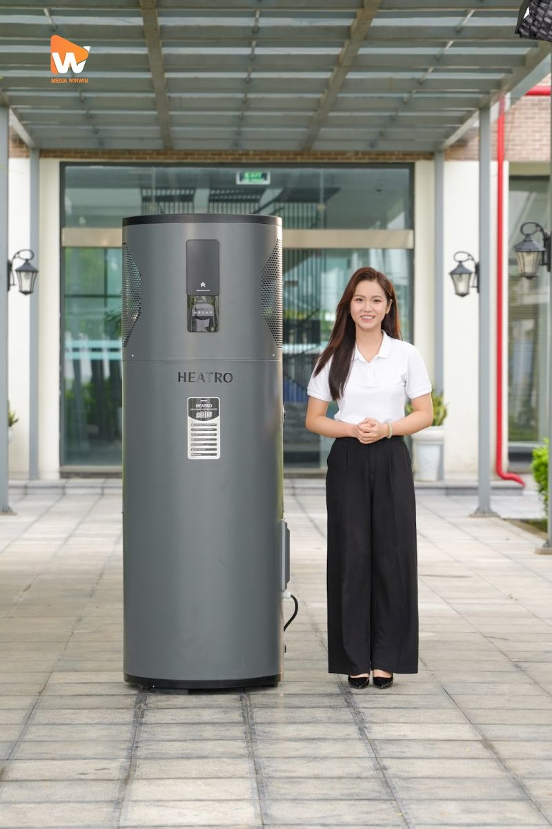 MC dẫn đứng cạnh máy bơm nhiệt HEATRO trong hậu trường quay review sản phẩm Sơn Hà tại Bắc Ninh