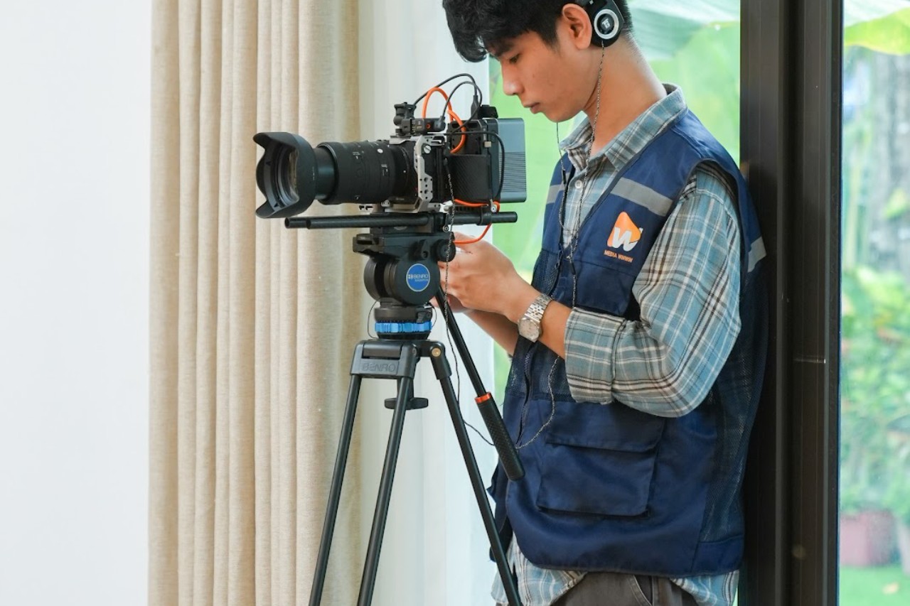 quay viên Media WinWin vận hành máy quay điện ảnh trên chân máy trong bối cảnh trong nhà dàn dựng để quay máy lọc nước RO SLIM Sơn Hà