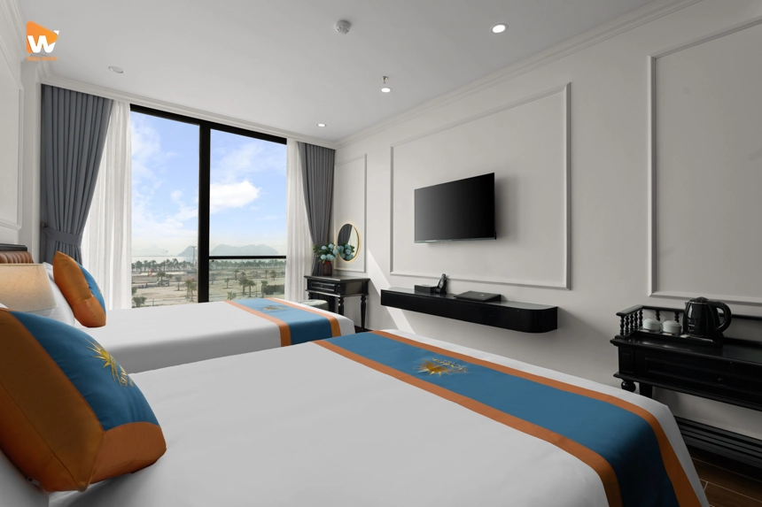 Phòng khách sạn được staging hoàn hảo với ga giường gọn gàng và bình hoa trang trí