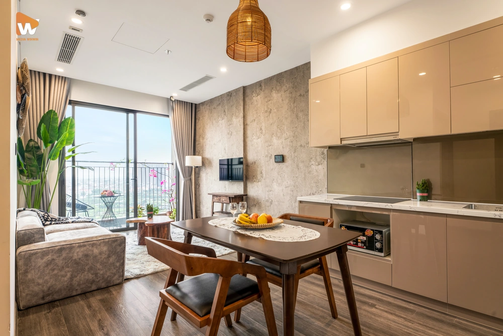 Ảnh chụp chuyên nghiệp không gian bếp và bàn ăn tại homestay Ocean Park, thể hiện sự tiện nghi, hiện đại và góc nhìn ra ban công xanh mát.