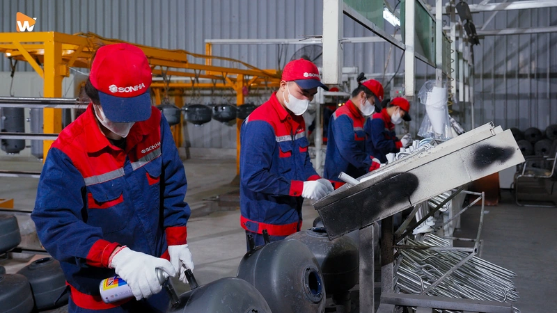 Nhân viên đang làm việc trong môi trường nhà máy sạch sẽ, hiện đại, thể hiện sự tự hào và gắn bó với công ty